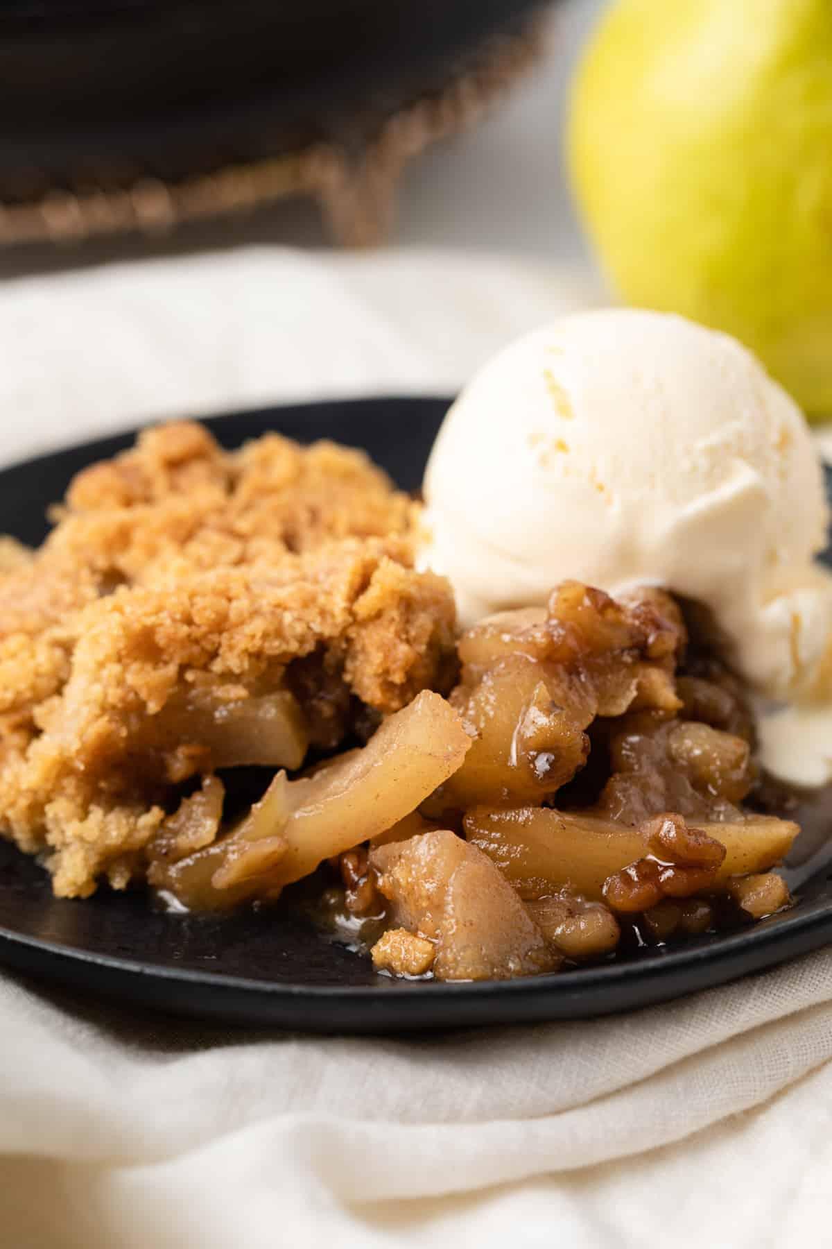 Warm maple walnut pear crisp with a scoop of vanilla ice cream