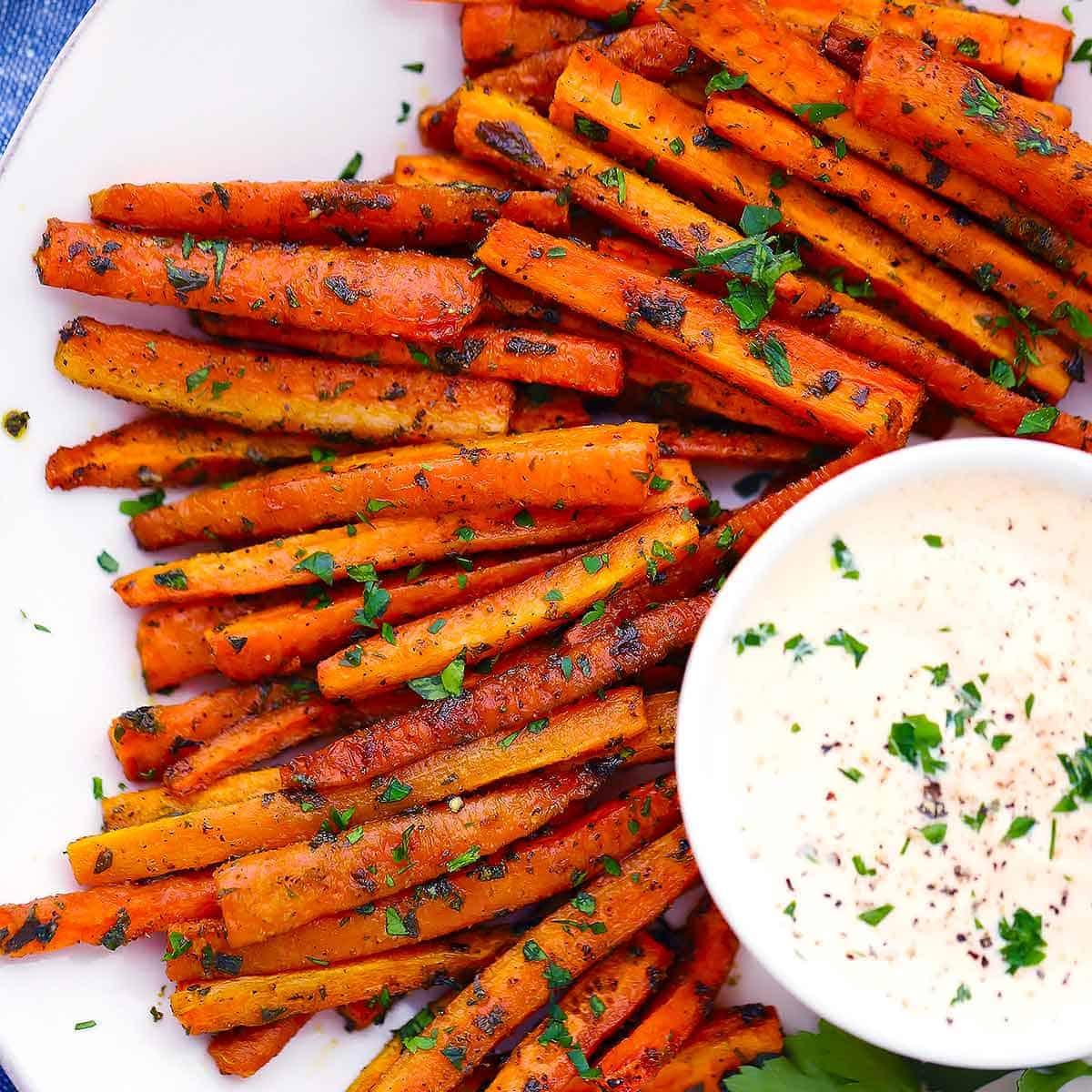 carrot fries being dipped in peanut sauce