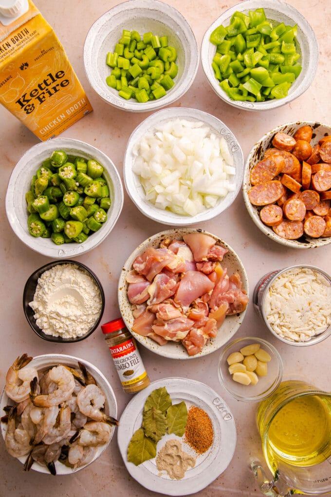 Ingredients for seafood gumbo laid out on a wooden table