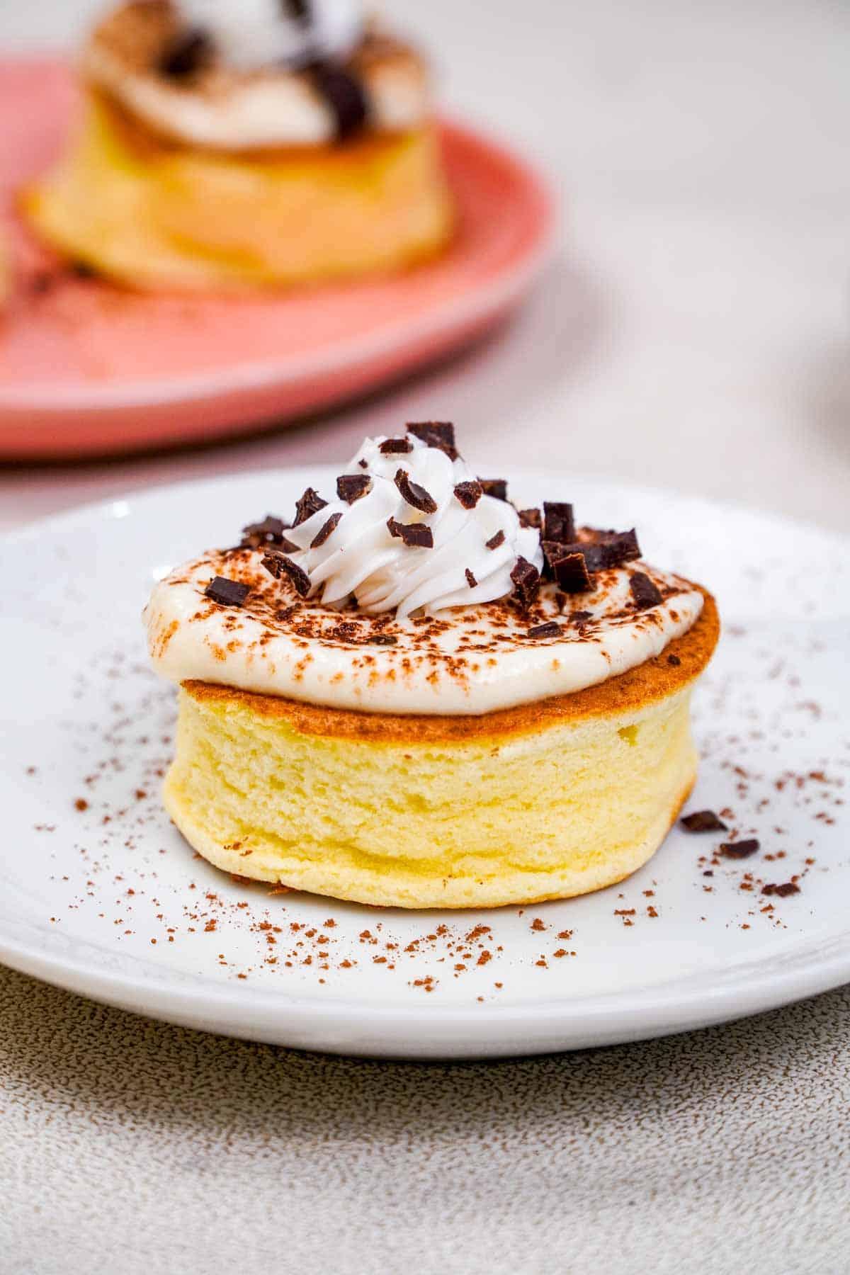 close up of a stack of gluten-free tiramisu pancakes being drizzled with mascarpone cream