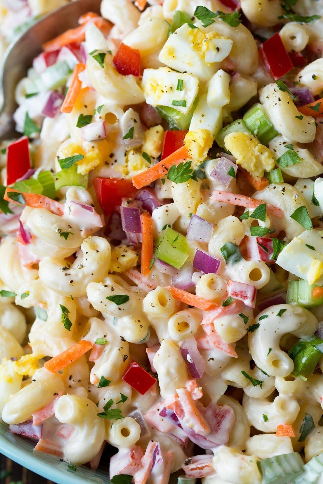 close up shot of summer macaroni salad being mixed