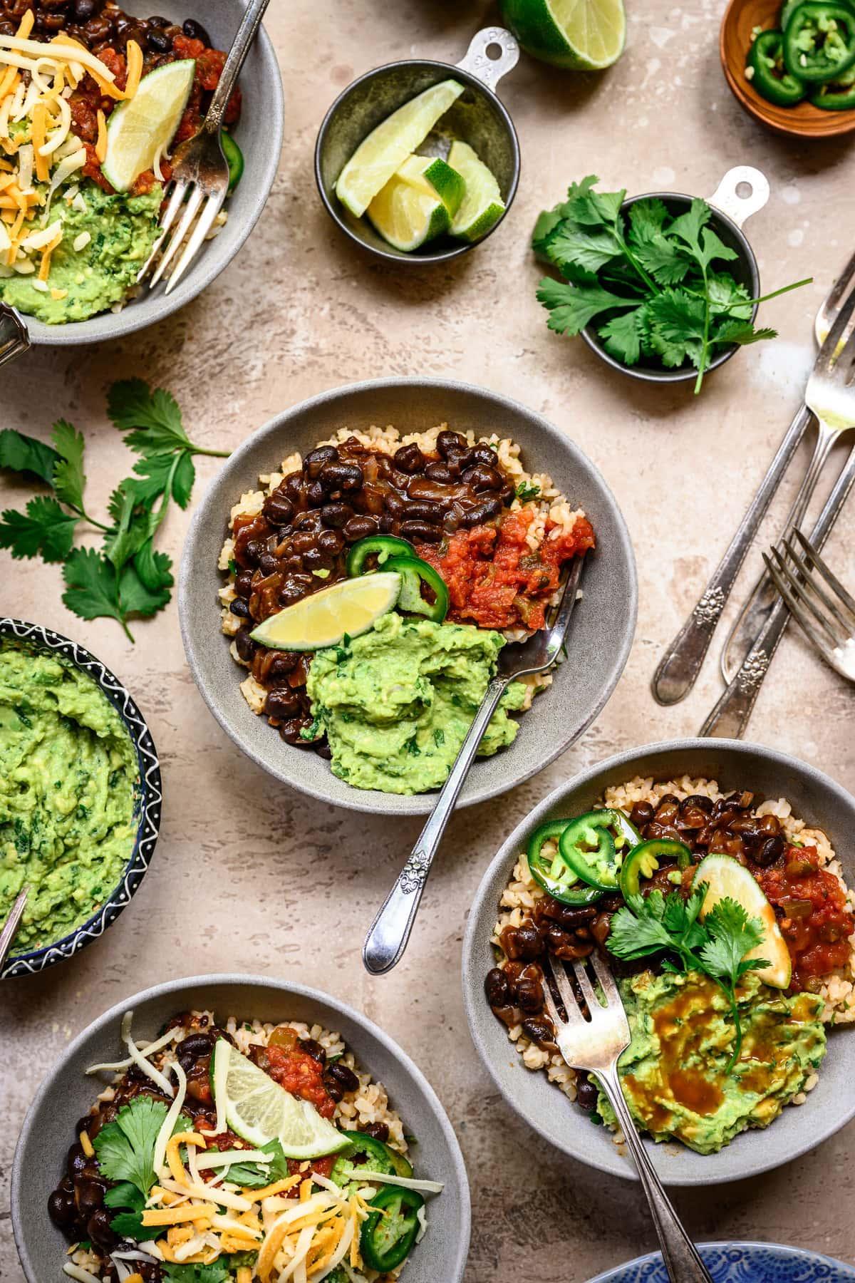 overhead shot of a person preparing a black bean burrito bowl in a kitchen
