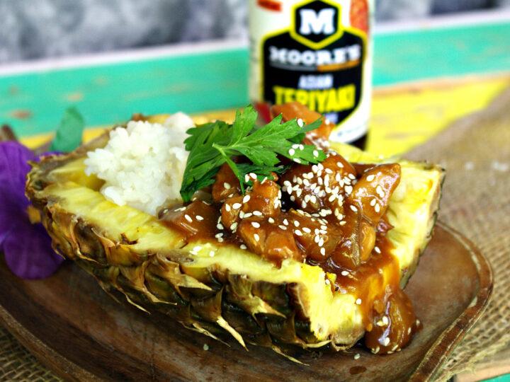 raw chicken breasts marinating in teriyaki sauce with pineapple chunks