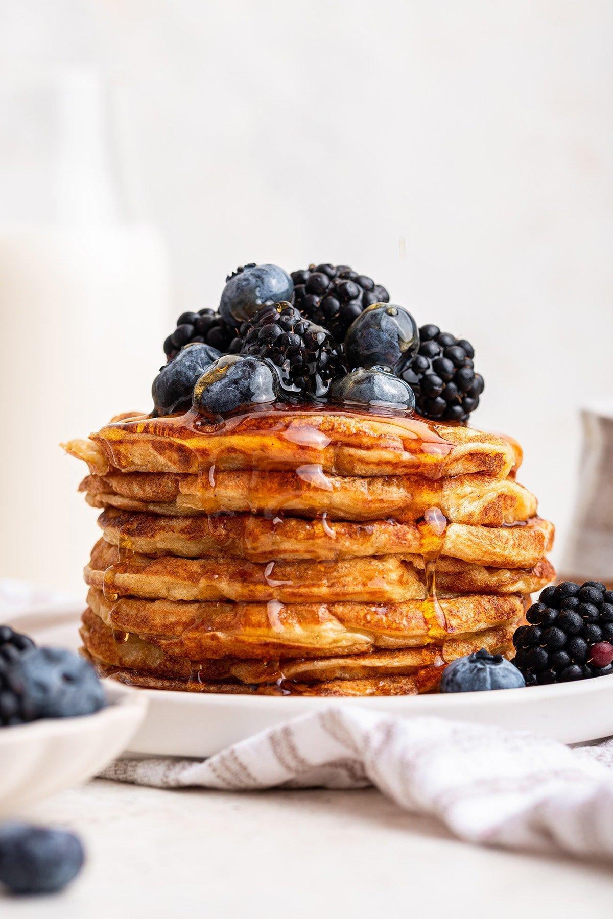stack of cottage cheese protein pancakes topped with berries and syrup