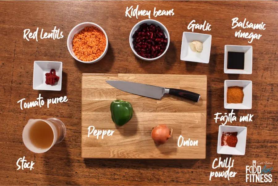 ingredients for spiced lentil and kale chili laid out on a wooden countertop