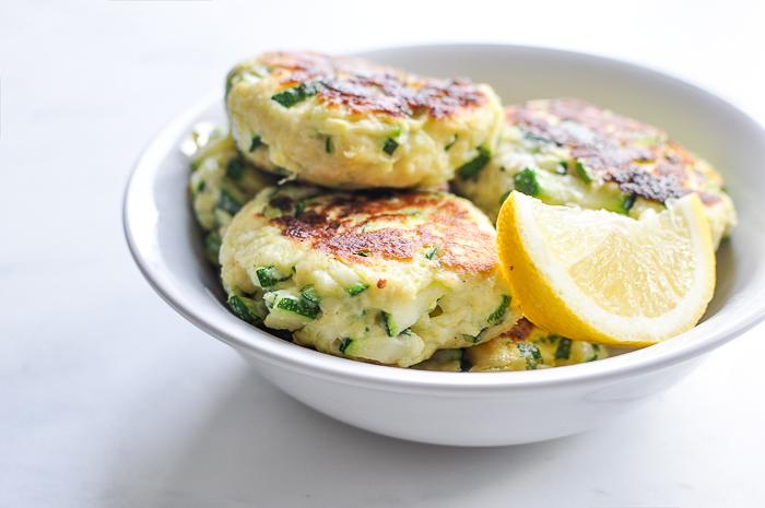 a person preparing a batch of zucchini ricotta fritters in a kitchen