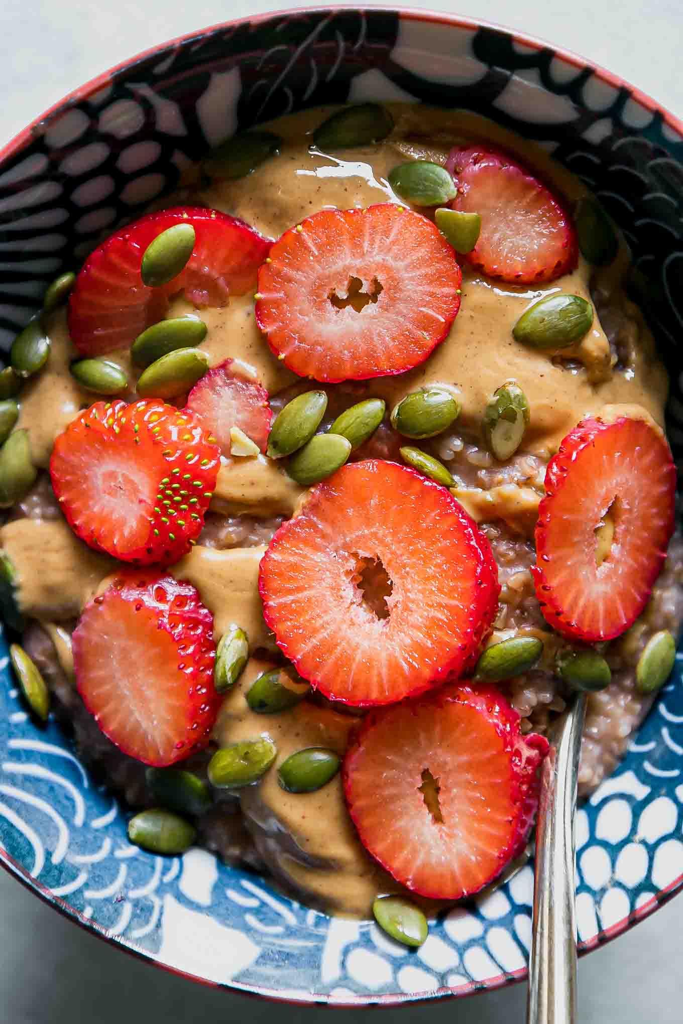 close-up shot of strawberries being sliced over a bowl of oatmeal