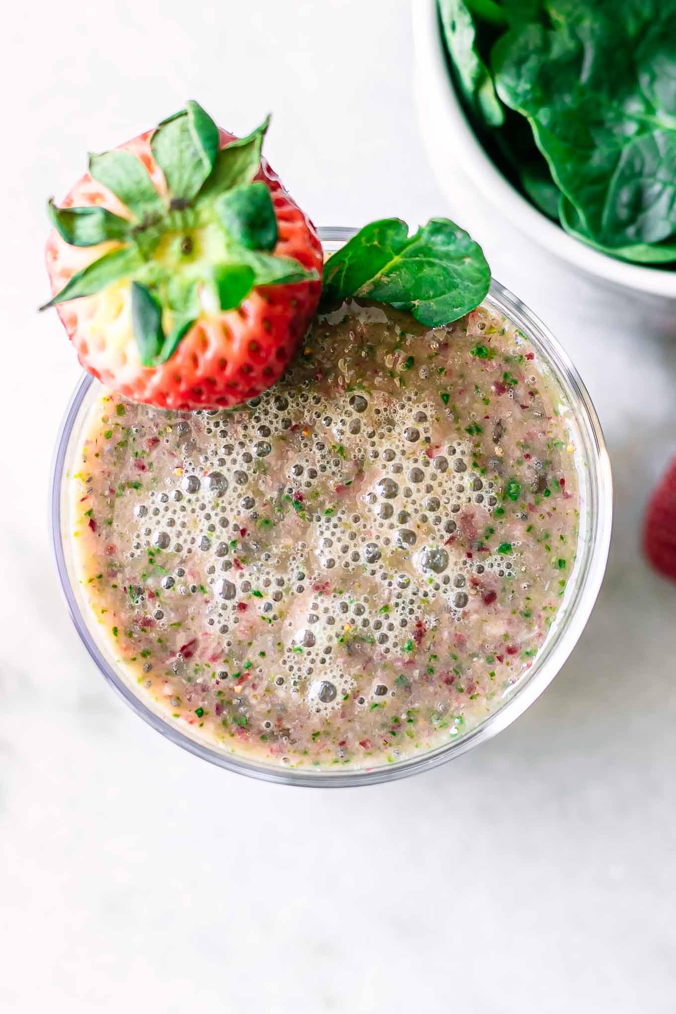 close-up of a strawberry spinach smoothie being poured into a glass