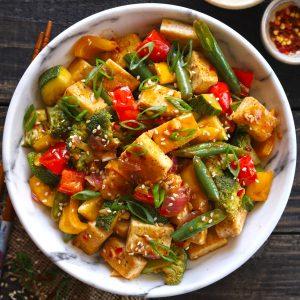 Colombian tofu stir-fry with colorful vegetables served in a rustic bowl