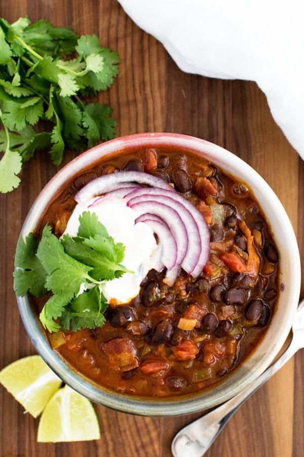 bowl of black bean and poblano chili garnished with lime and cilantro