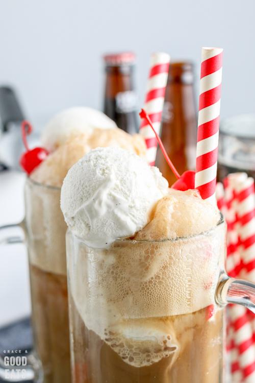 pouring homemade root beer over vanilla ice cream in a glass