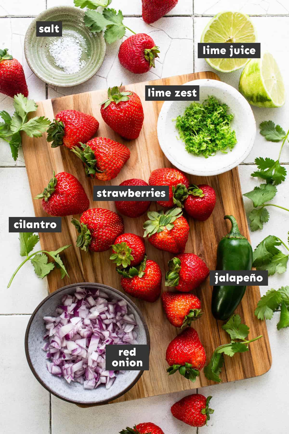 ingredients for strawberry salsa laid out on a kitchen counter