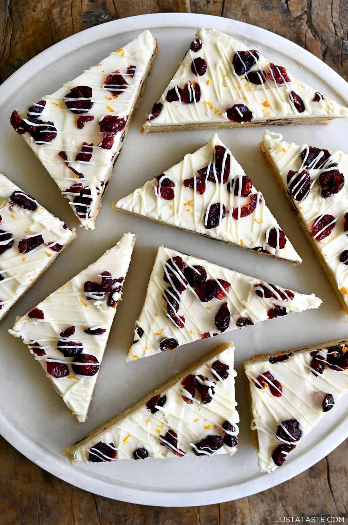 Platter of cranberry bliss bars with white chocolate drizzle and orange zest