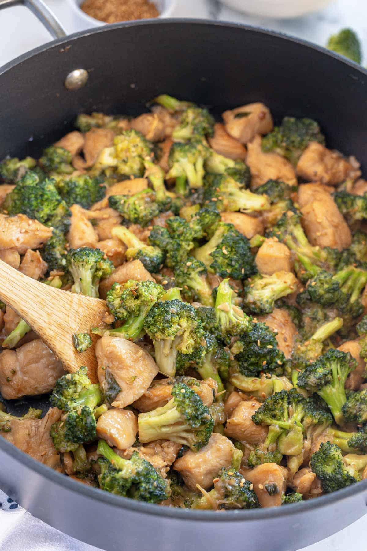Close-up of chicken and broccoli stir-fry being tossed in a wok
