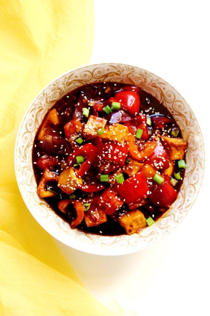 close up shot of spicy chili with tofu being stirred in a pot