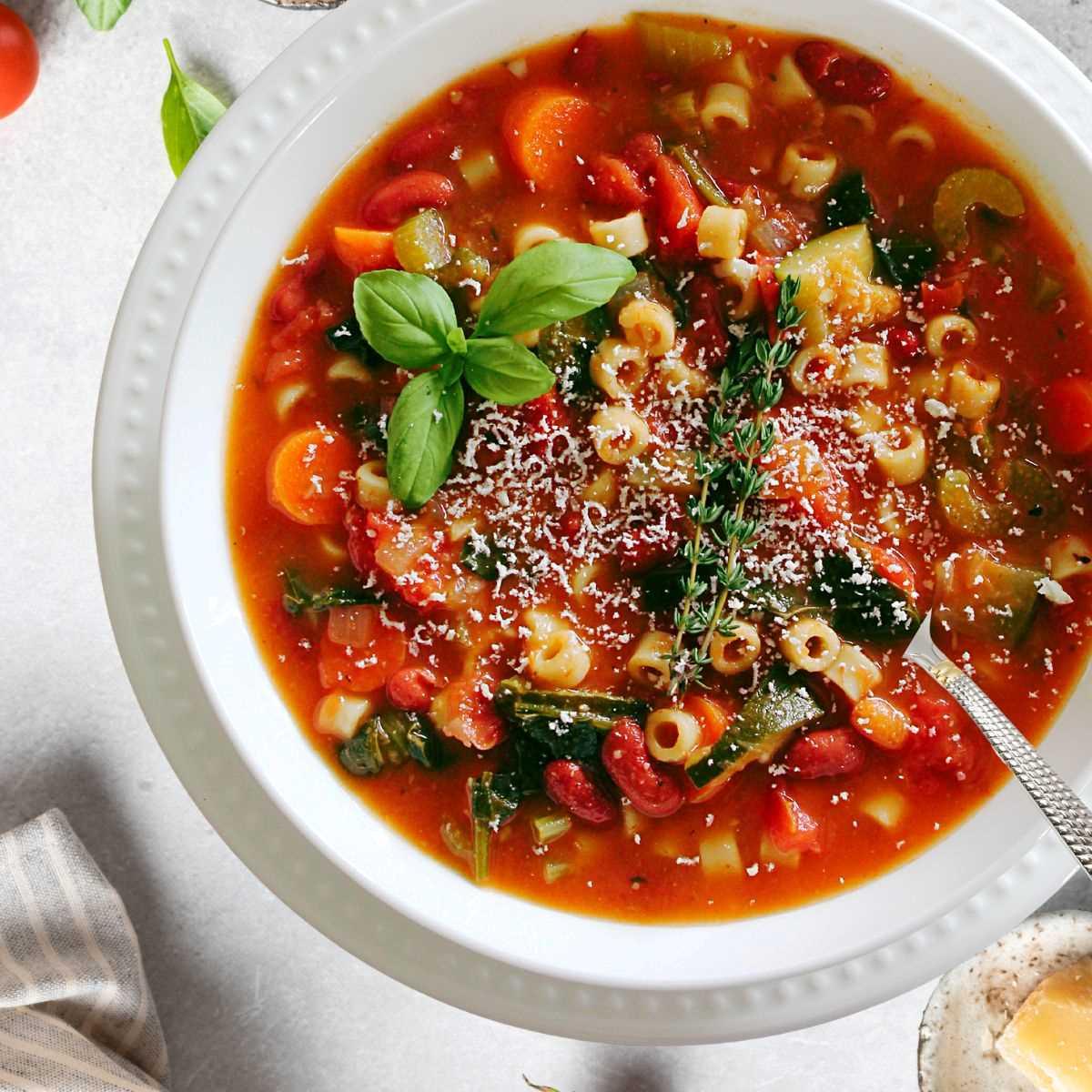 close up of italian summer minestrone soup being stirred in a pot