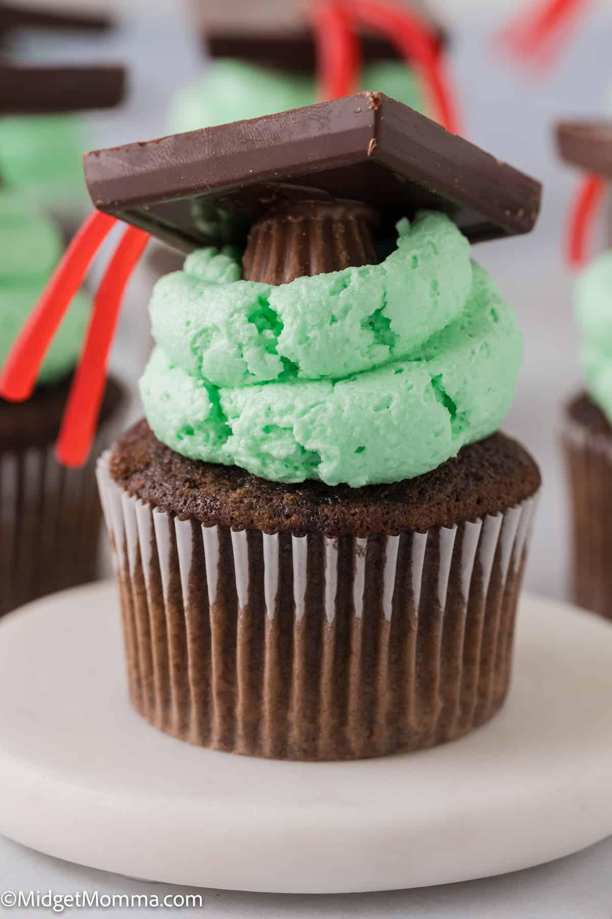 close-up of a green cupcake decorated with a miniature graduation cap