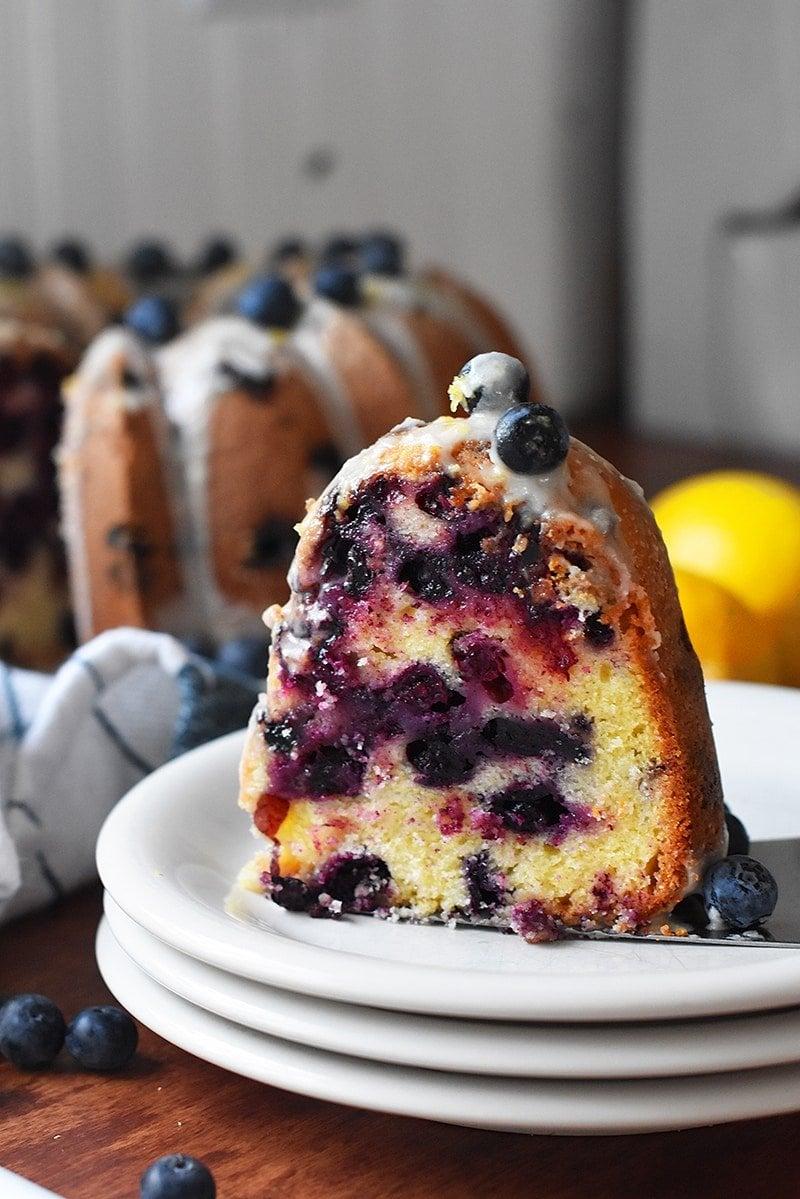 Woman dipping blueberry lemon cake pops in glaze