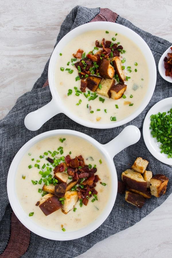 bowl of cheddar ale soup with pretzel croutons, garnished with chives
