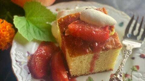 Peach ricotta cake being served with whipped cream and a sprig of mint