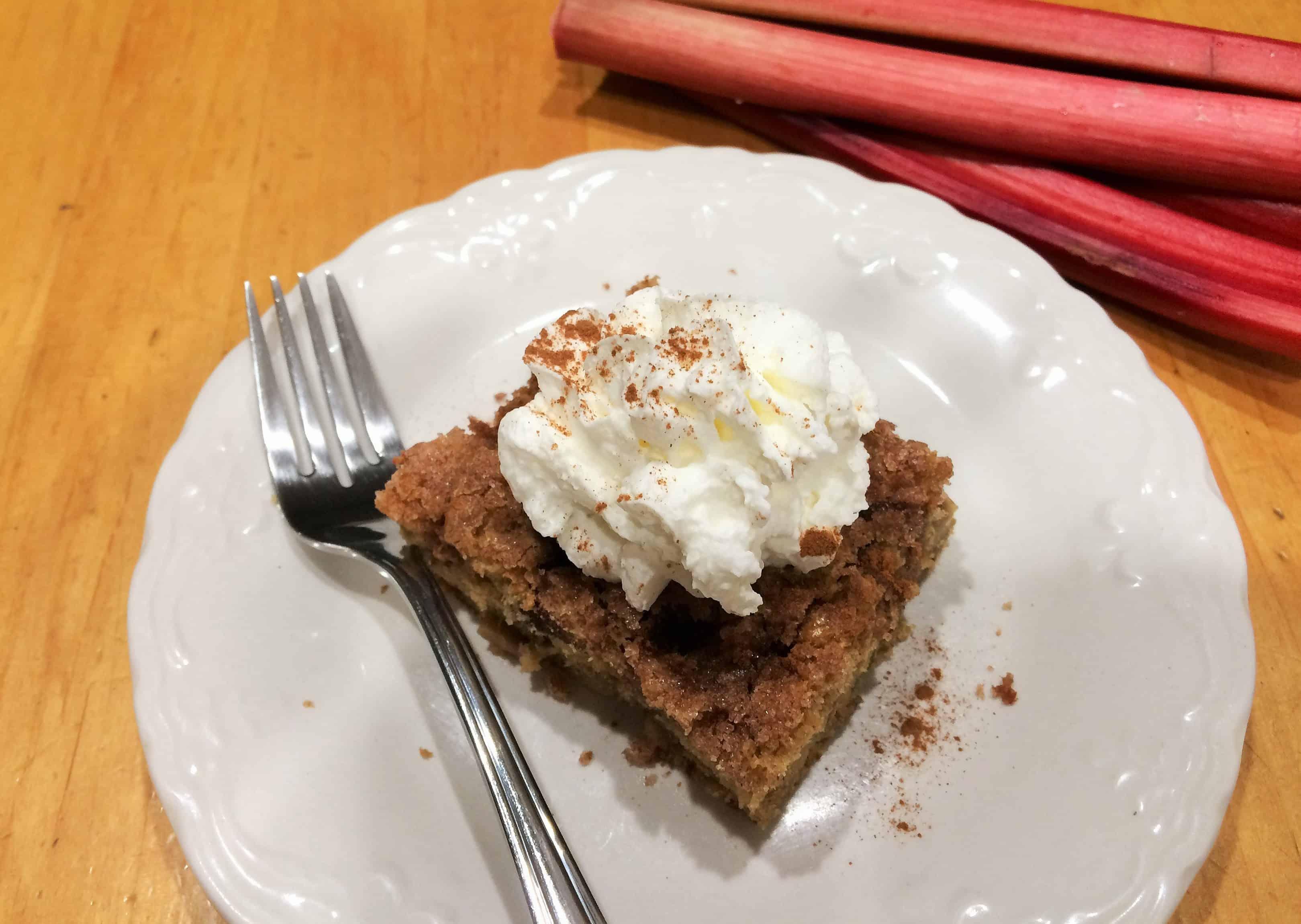 slice of rhubarb and walnut cake on a plate with a fork