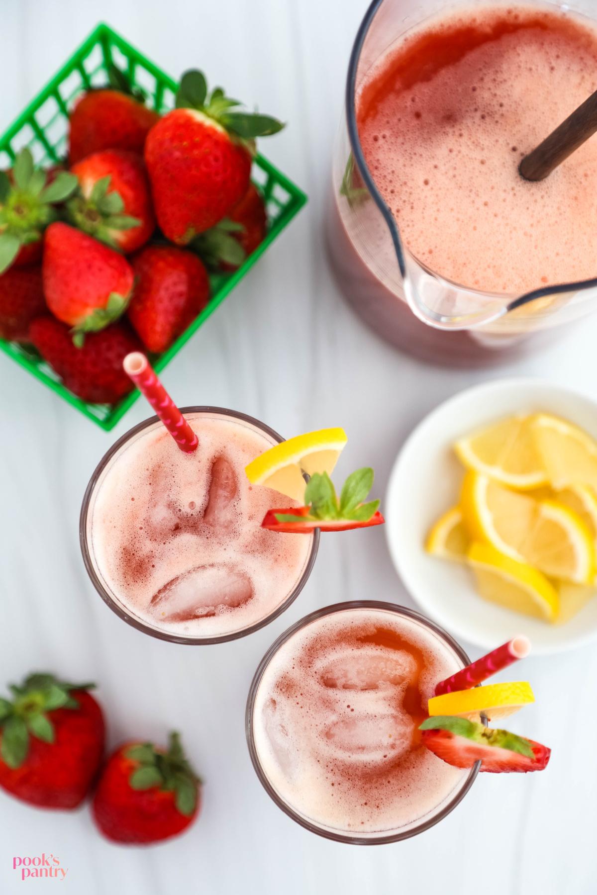 overhead shot of a pitcher of strawberry lemonade spritzer being poured into glasses
