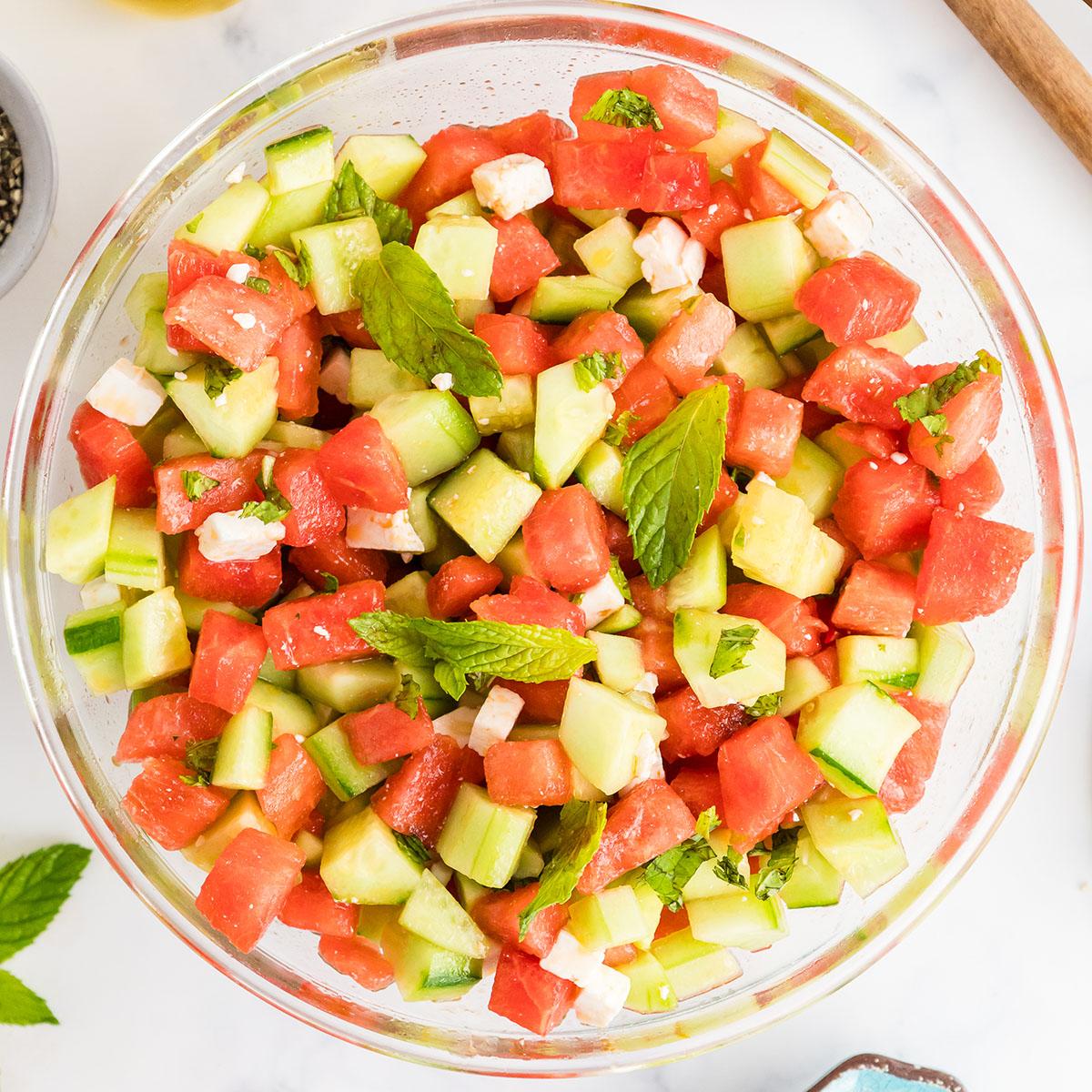 watermelon cucumber pasta salad being served from a large bowl