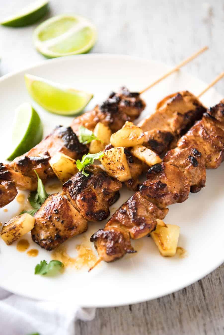 grilled pineapple and coconut chicken skewers on a tropical background