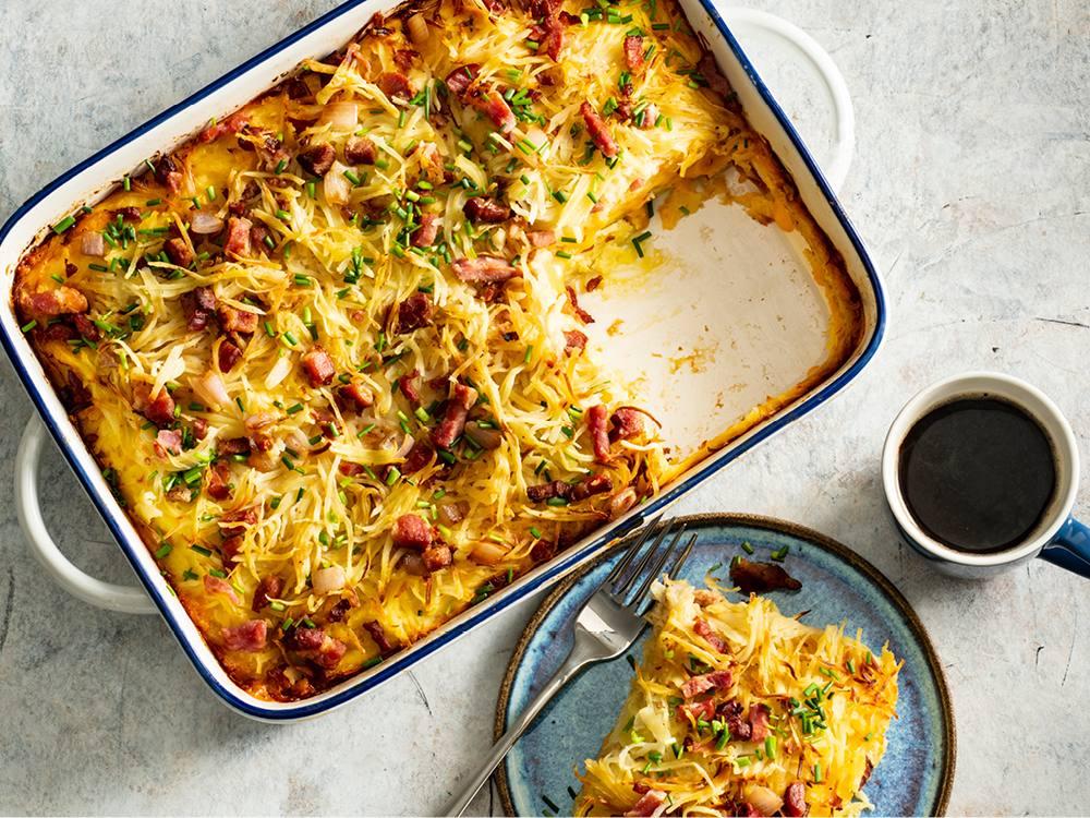 A beautifully golden-brown breakfast casserole with hash browns, eggs, cheese, and bacon, ready to serve in a rustic dish on a brunch table