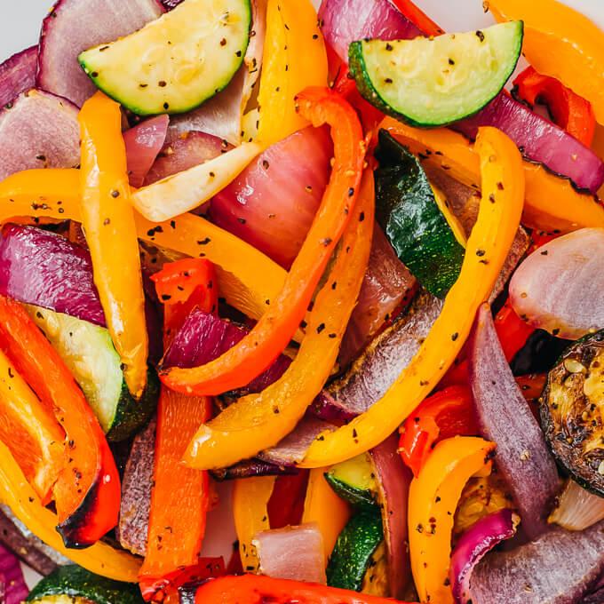 close-up of colorful bell peppers and sliced onions arranged on a sheet pan