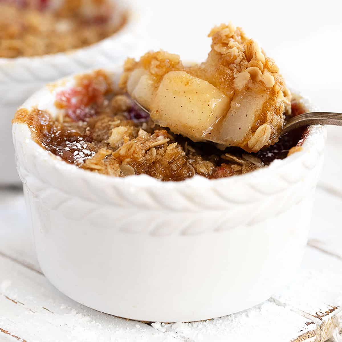individual servings of cranberry pear crisp with a scoop of vanilla ice cream