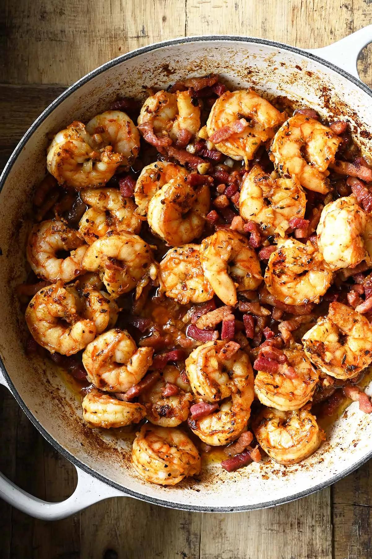bacon garlic butter shrimp being stirred in a skillet