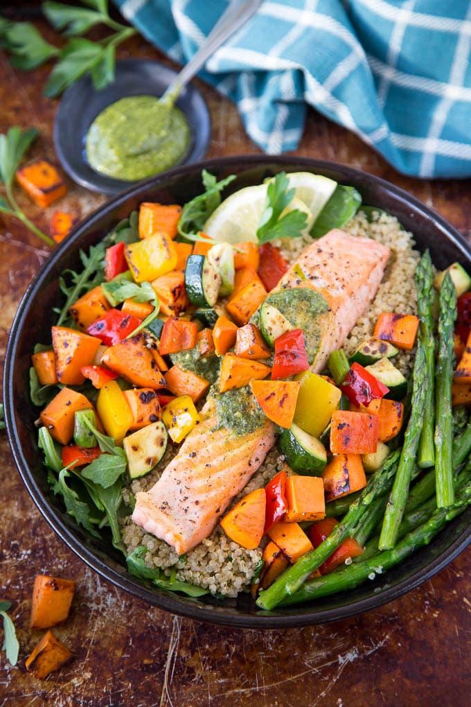 overhead shot of salmon with roasted vegetables and quinoa in a serving bowl