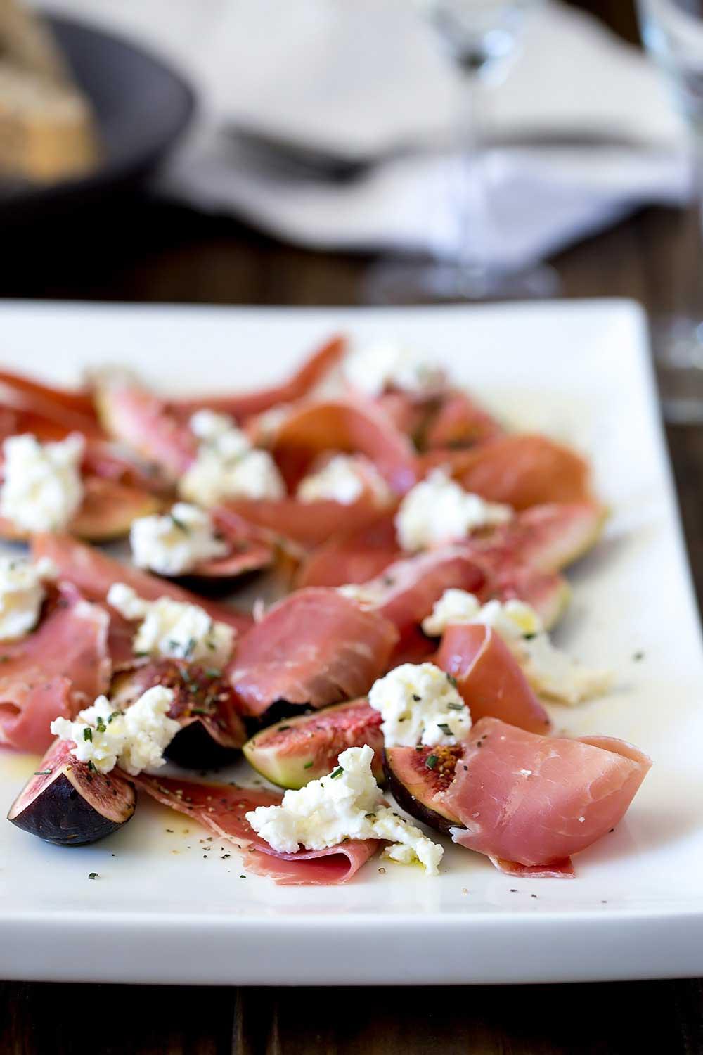 Close-up of a plate with a perfectly arranged fig and prosciutto salad