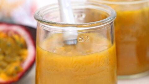 close up of passion fruit pulp being spooned into a parfait glass