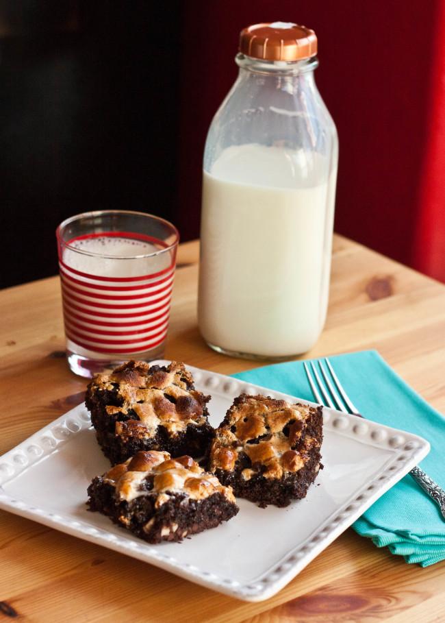 a plate of rocky road brownies next to a glass of milk