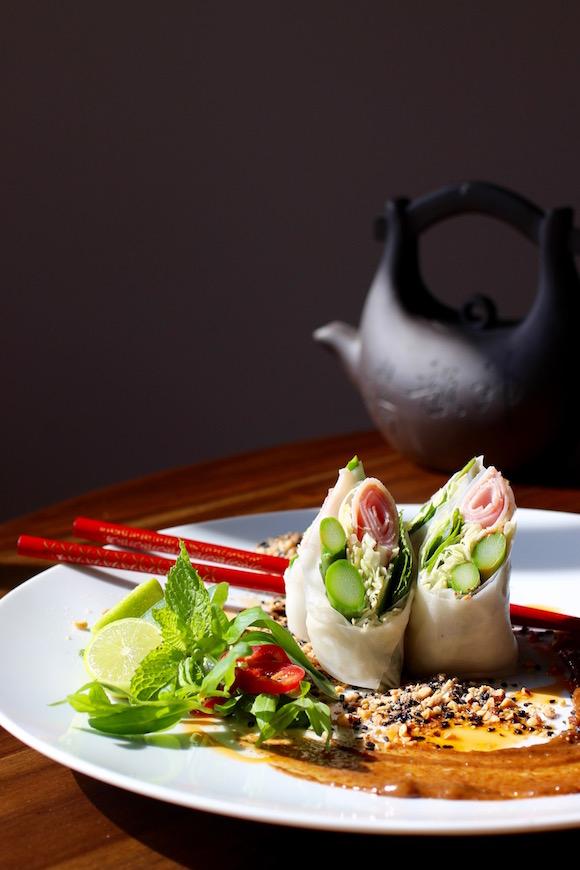 Ingredients for ham and asparagus spring rolls laid out on a table