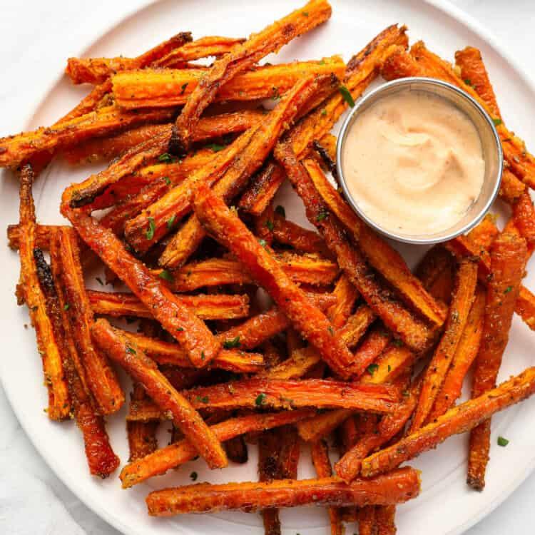 close up of baked curried carrot fries on a baking sheet, showing the crispy texture
