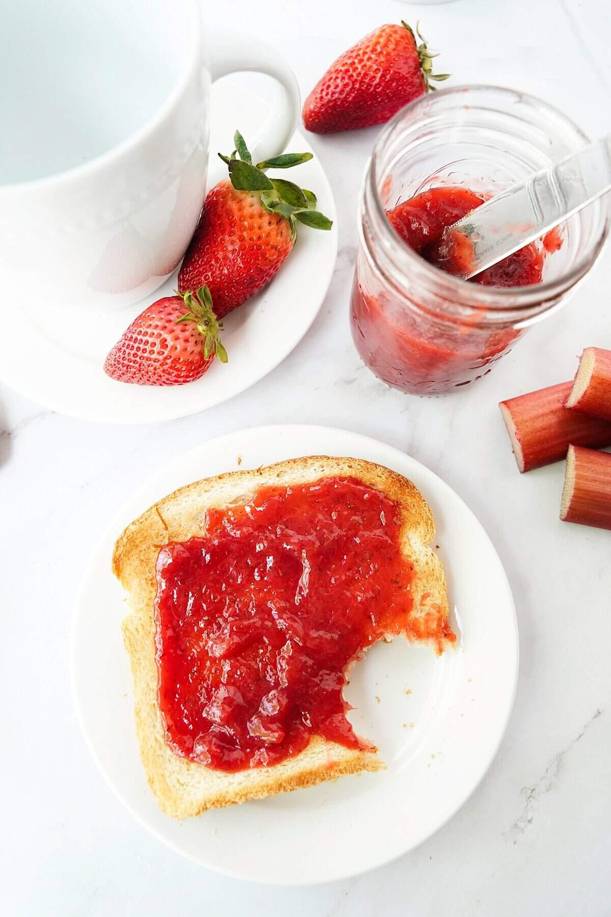 a close-up of sliced strawberries and rhubarb stalks ready to be cooked into jam