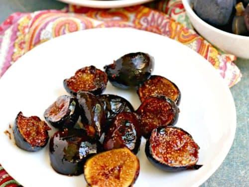 Close-up of balsamic glaze being drizzled over fresh figs