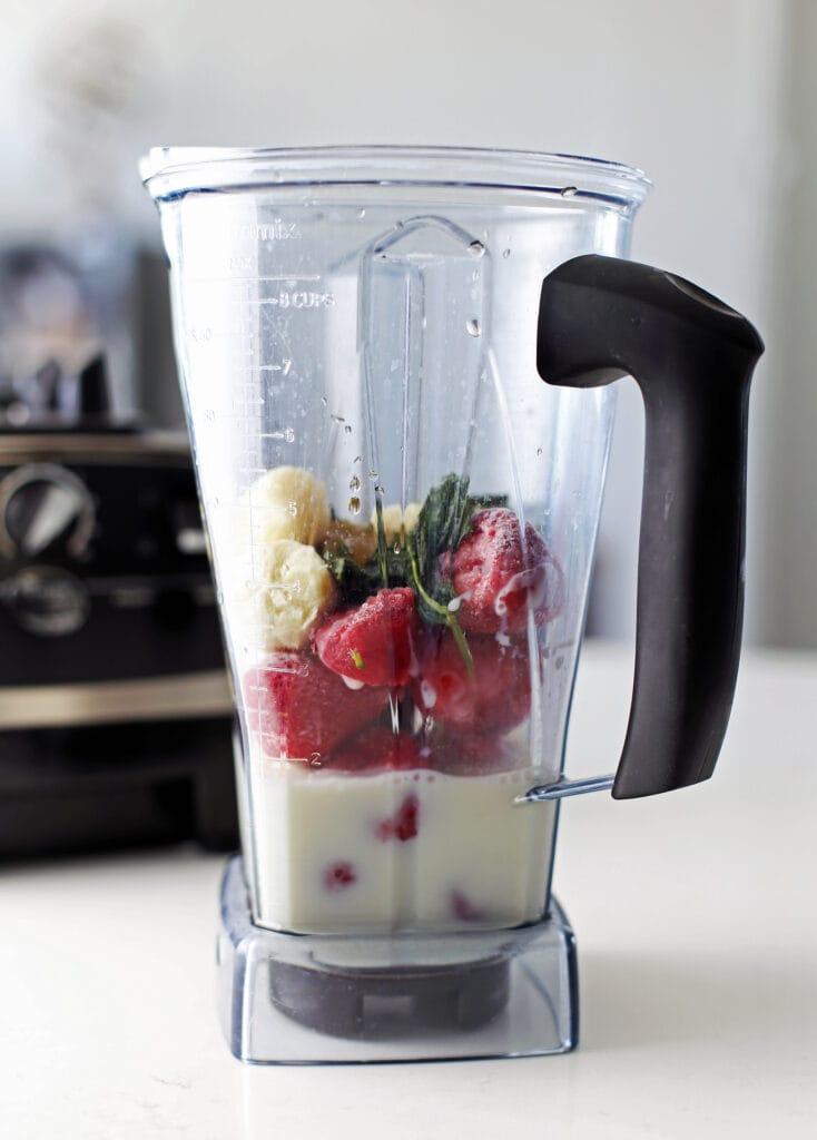close-up shot of a blender creating a berry mint smoothie