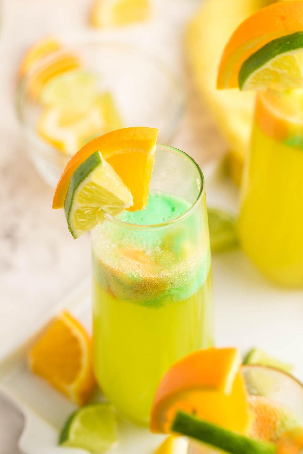 a pitcher of rainbow sherbet lemonade with lemon wedges