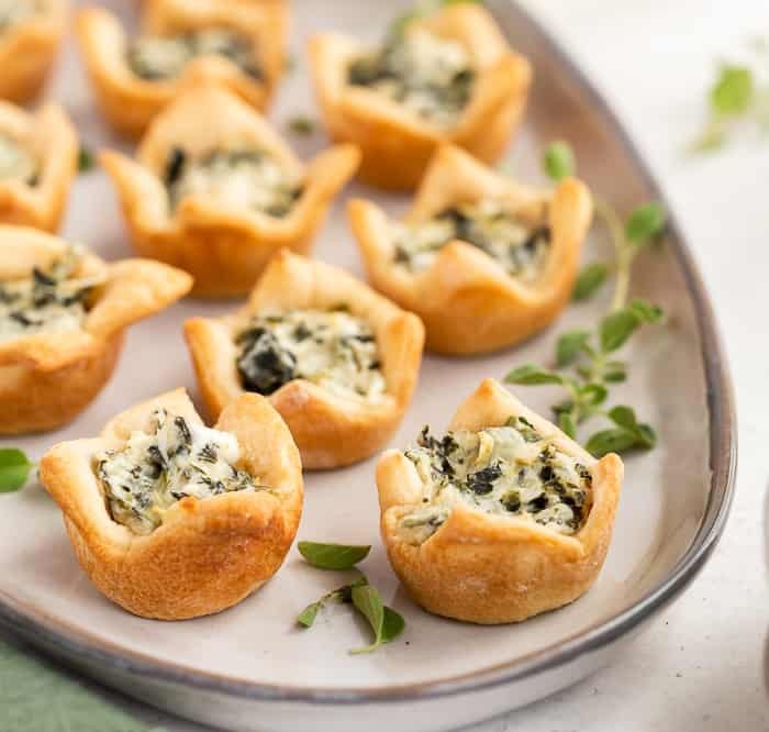 Delicious spinach and artichoke dip bites on a serving platter at a party