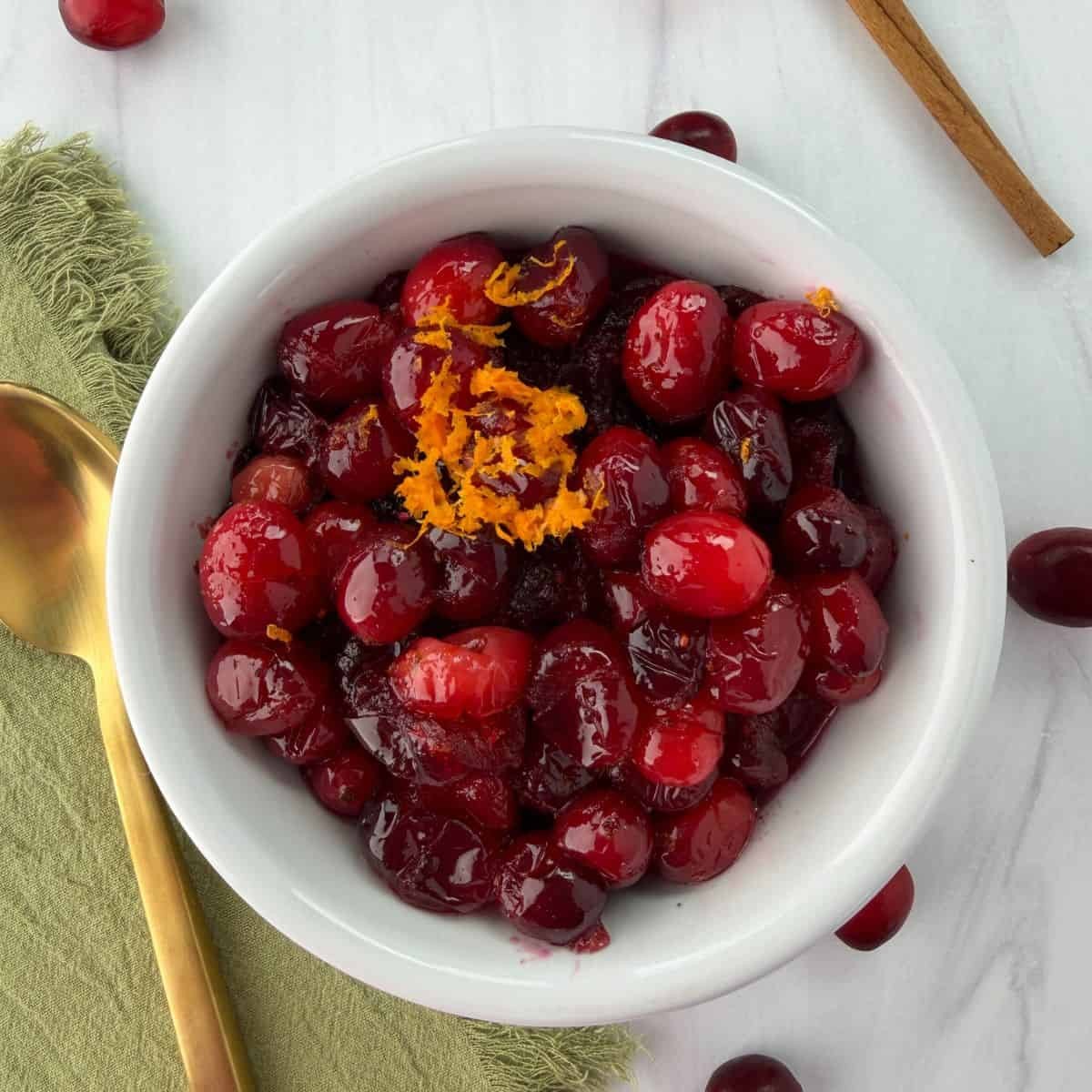 Homemade whole berry cranberry sauce with orange zest and fresh cranberries in a bowl