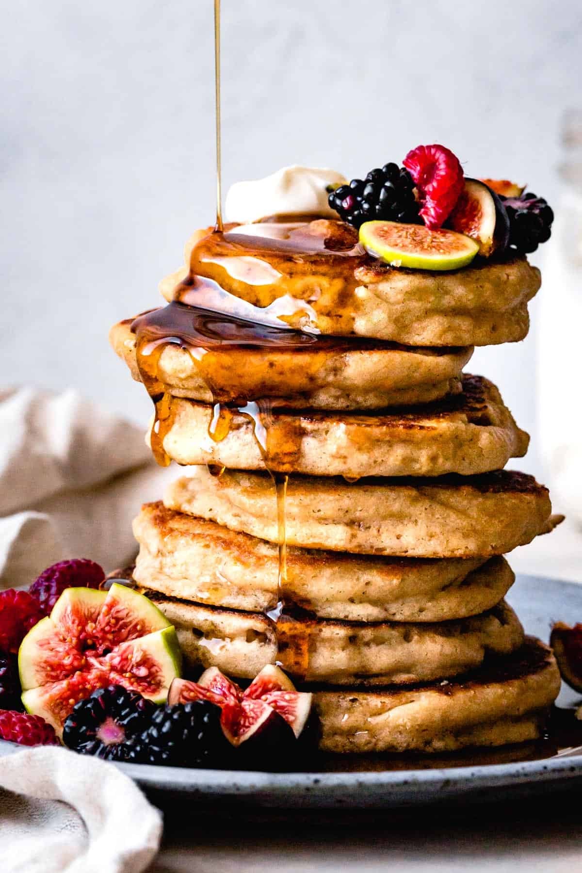 stack of gluten-free sorghum pancakes with fresh berries and maple syrup