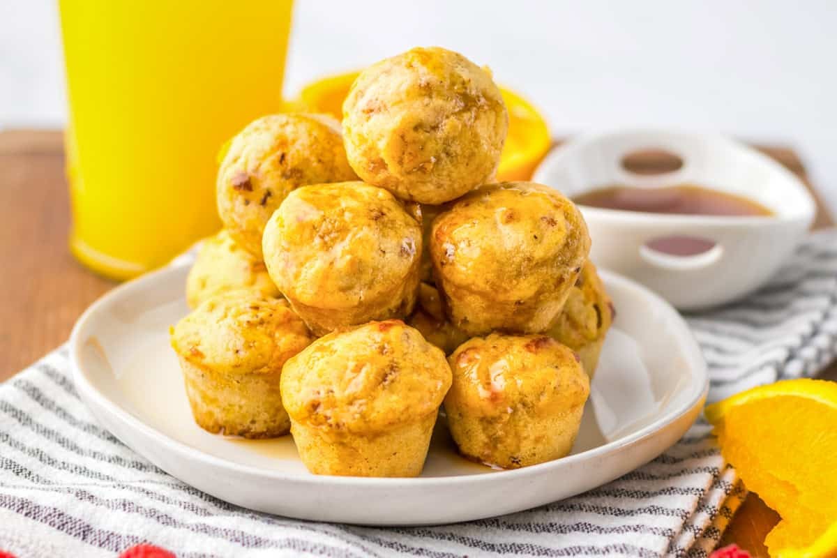 Close up shot of homemade McGriddle bites with maple syrup and sausage patty, golden brown pancakes, on a white plate