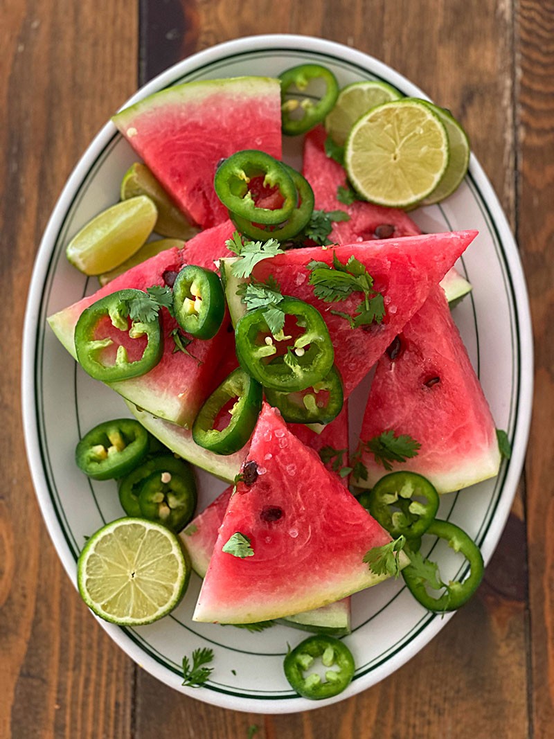 Spicy watermelon radish rocket salad with lime wedges