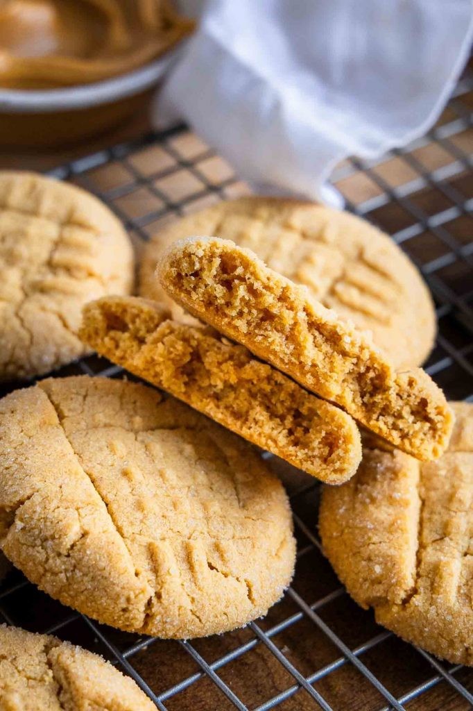 freshly baked peanut butter cookies with perfect fork crisscross pattern on cooling rack, warm golden brown