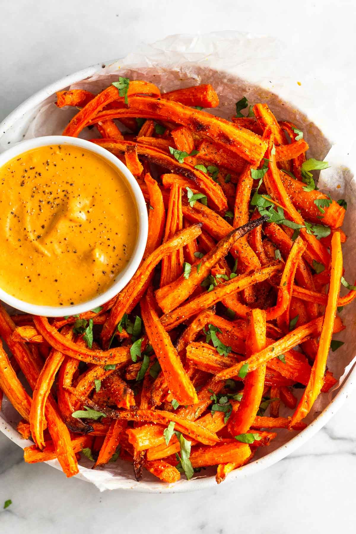 close-up shot of coconut curry lime carrot fries with dipping sauce