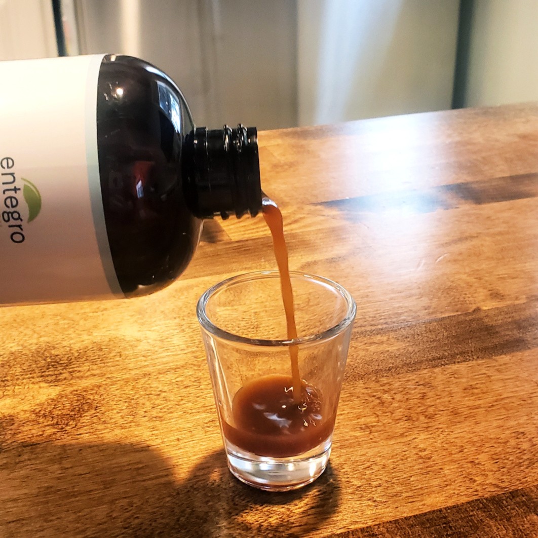 close-up shot of probiotic cold brew being poured into a glass with visible probiotics swirling